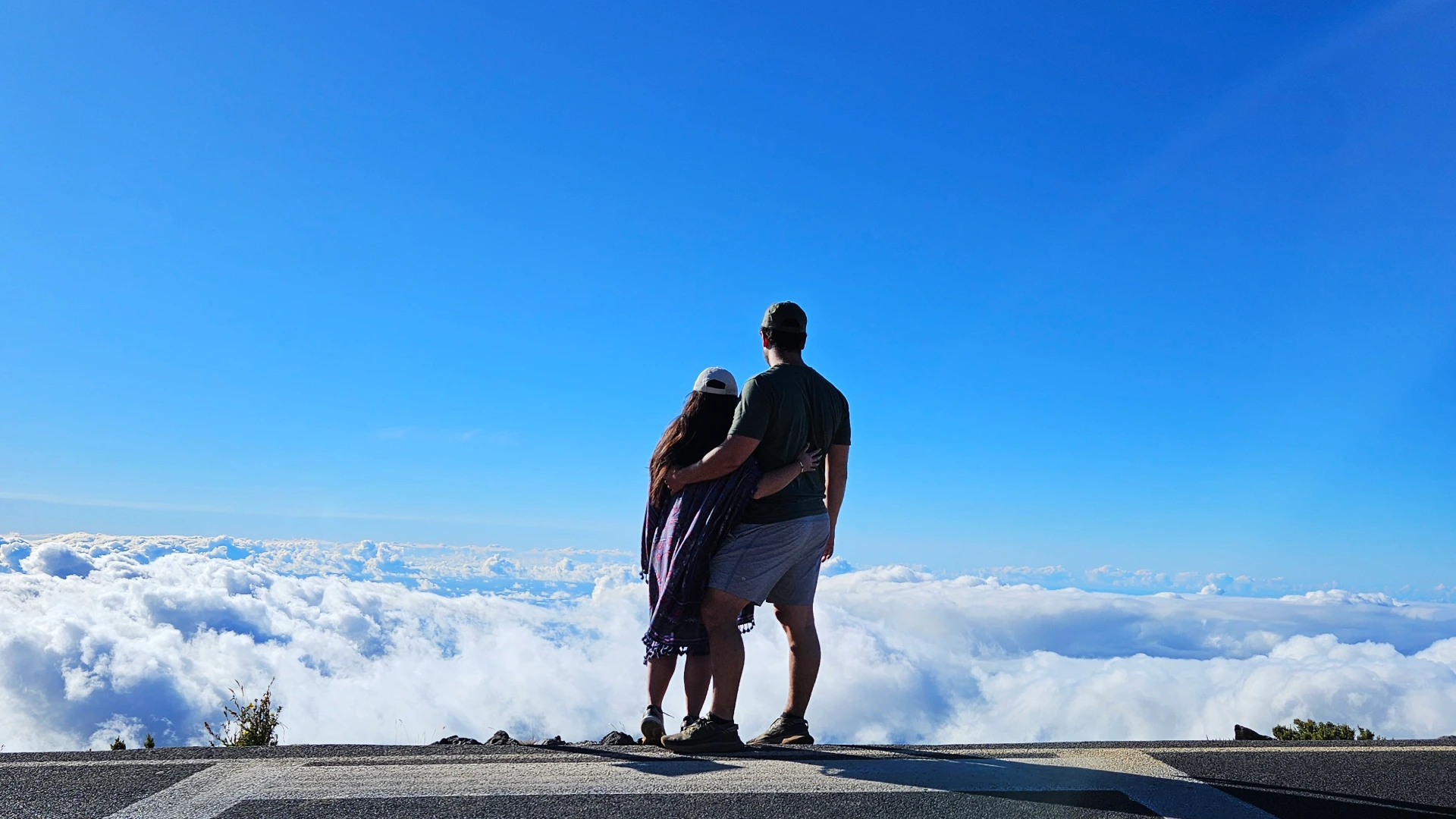 Tim and Zoe surrounded by clouds while looking out into the distance at a lookout in Haleakala, Maui, Hawaii.