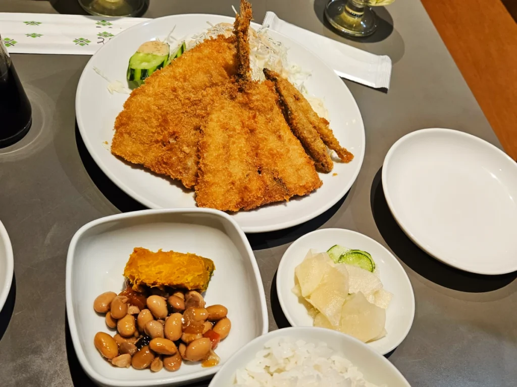Fried catfish and sardines surrounded by Japanese snacks.