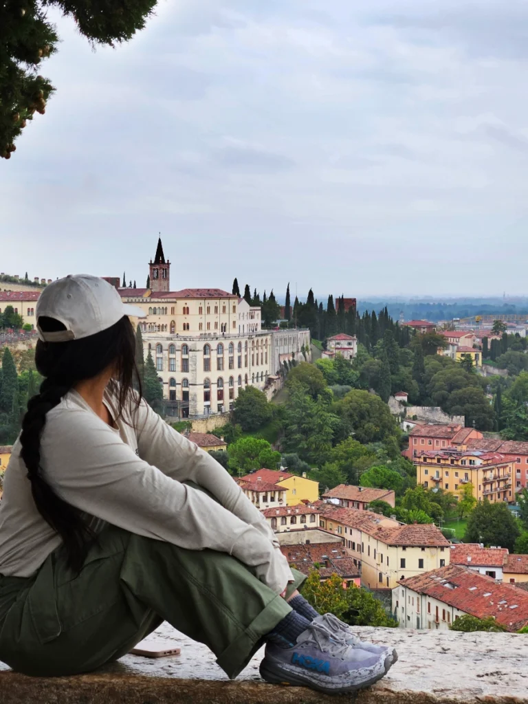 Zoe enjoying the view while sitting on a ledge at Castel San Pietro overlooking Verona.