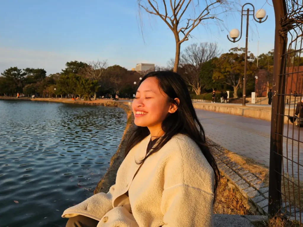 Zoe sitting next to Ohori Pond soaking up the golden rays of the sun as the sun begins to set.