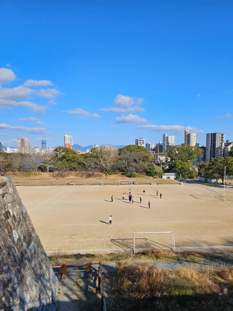 Overlooking an all dirt soccer field with a group of friends playing.