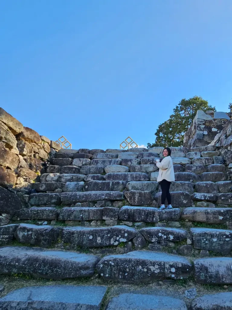 Zoe posing on giant rock steps at the Fukuoka Castle Ruins.
