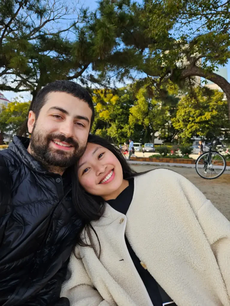 Tim and Zoe sitting on a bench at Ohori Park.