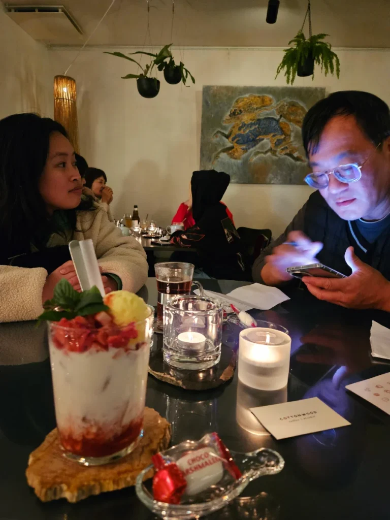 Zoe and Michael at Cottonwood Cafe in Beppu, with a strawberry yogurt drink in the front of the frame.