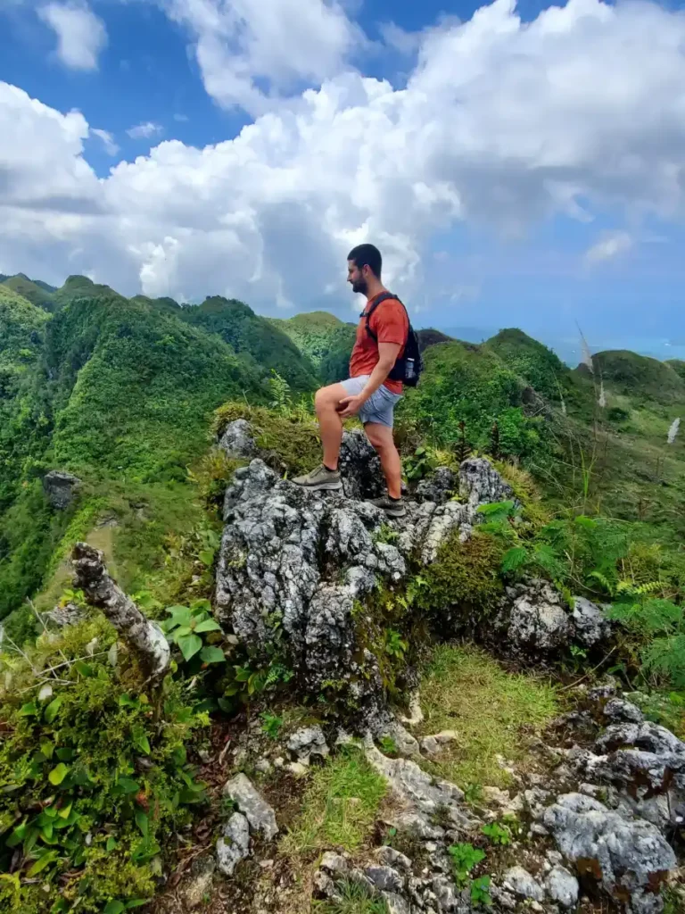 Tim standing on top of Kandungaw Peak, located in Cebu, Philippines. Image portrays an example of a slow travel activity during the discussion of slow travel vs. fast travel.