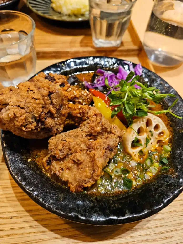 A delicious bowl of soup curry featuring karaage and lotus root.
