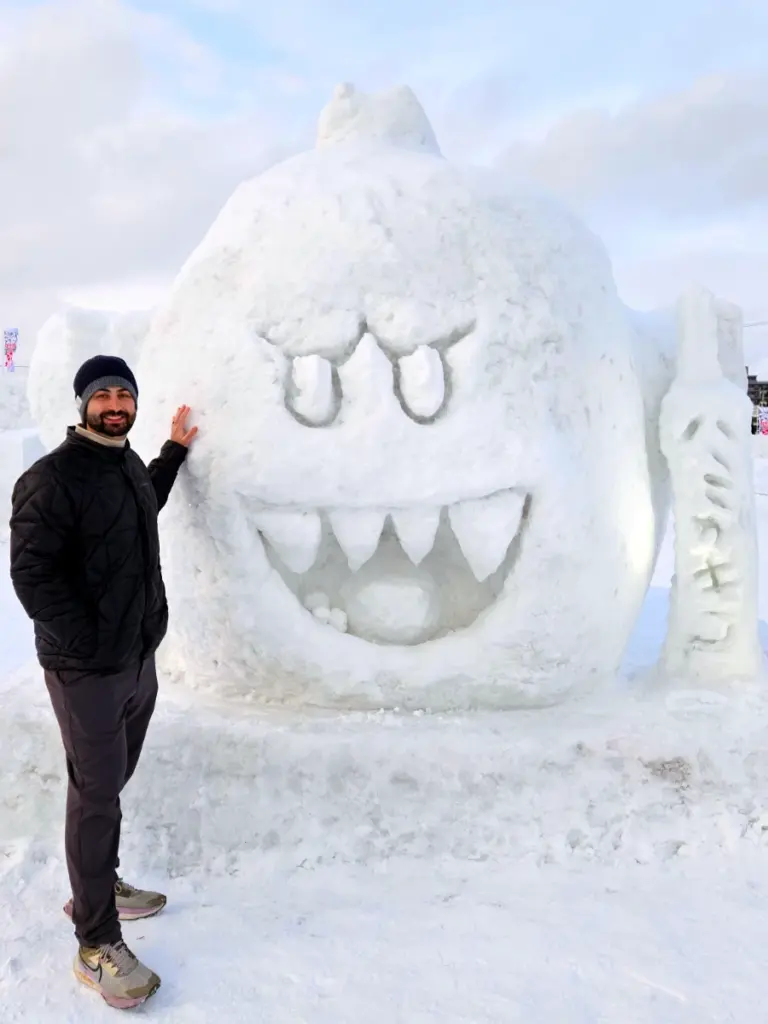 Tim standing next to a giant King Boo snow sculpture.