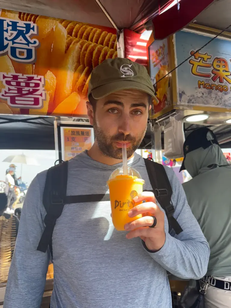 Tim drinking a mango slushy to beat the summer heat at the Dongshi Dragon Boat Festival.