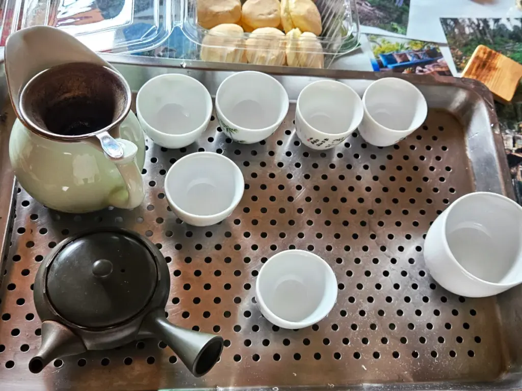A metal tray prepared with white porcelain cups and a traditional teapot, ready for a traditional Taiwanese tea ceremony.