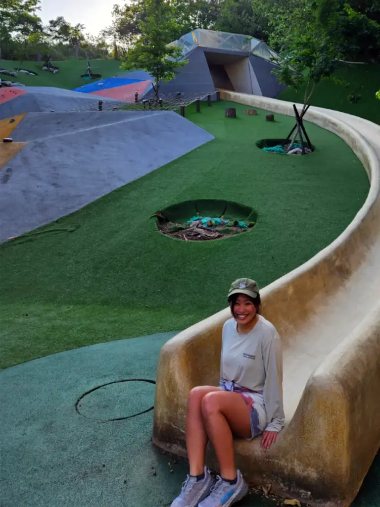 Zoe sitting at the bottom of the famous 50-meter concrete slide at Wenshan Forest Park.